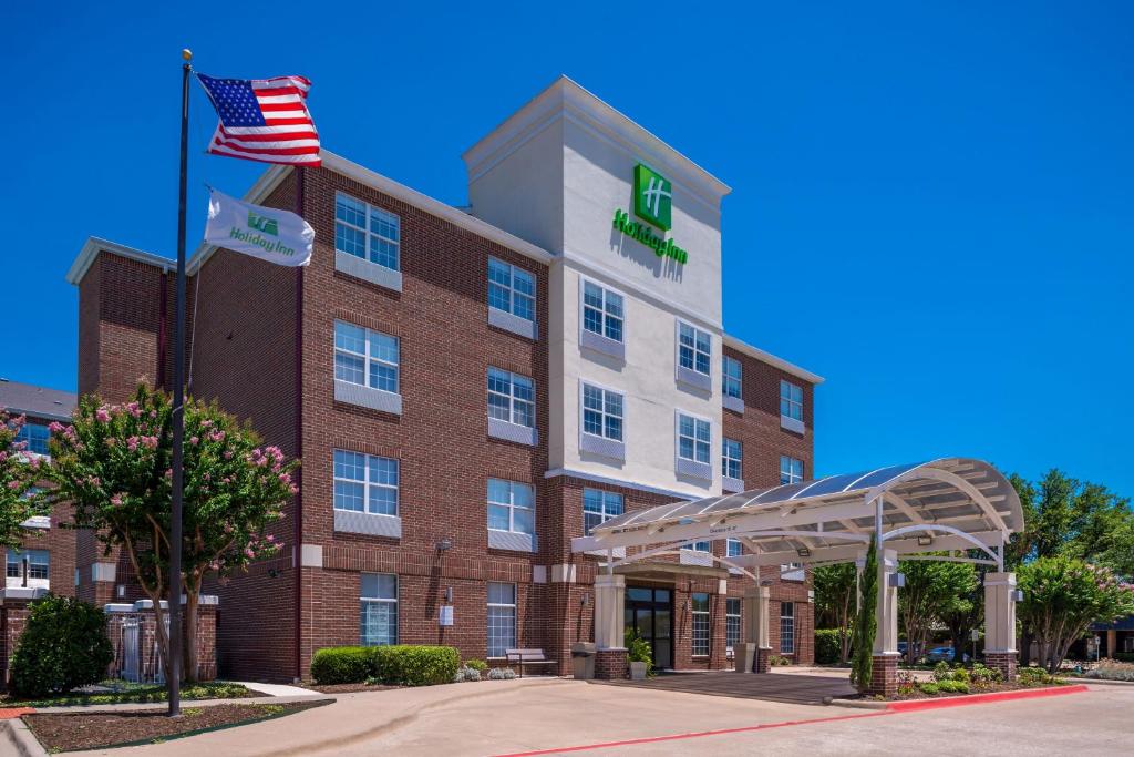 an image of a hotel with an american flag at Holiday Inn and Suites Addison, an IHG Hotel in Addison