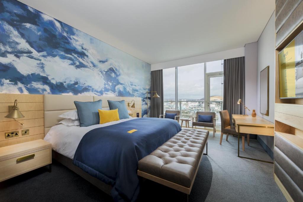 um quarto de hotel com uma cama grande e uma secretária em voco St. David's Cardiff, an IHG Hotel em Cardiff