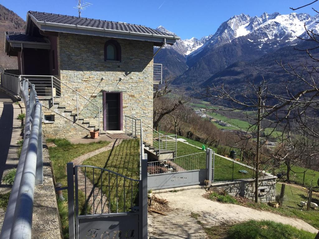 a house with a gate and stairs leading up to a mountain at incantevole in Malonno