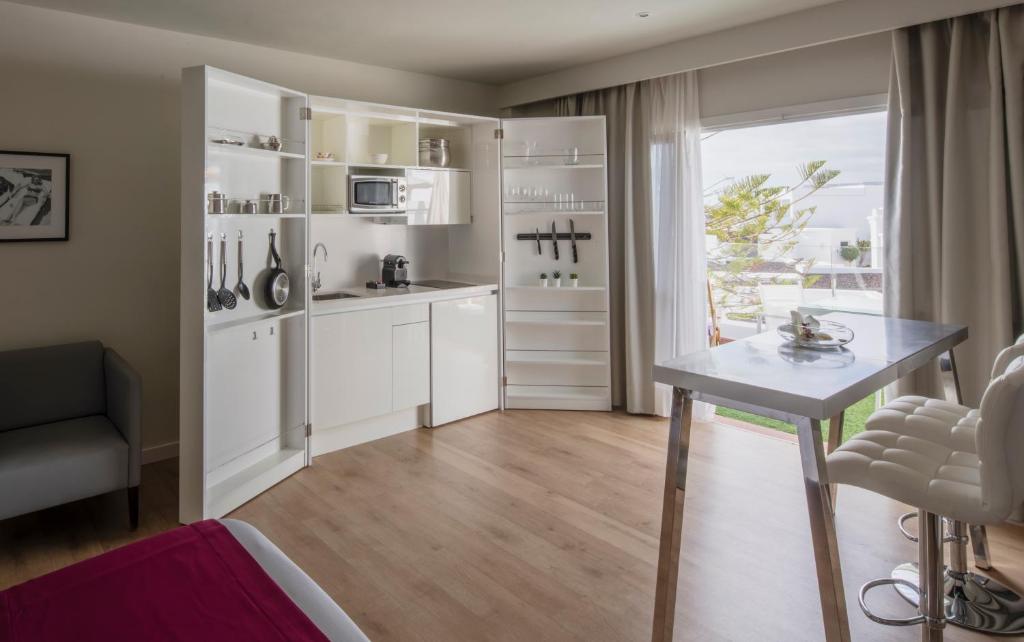 a kitchen with white cabinets and a table and a window at Flamingo Beach Mate in Adeje