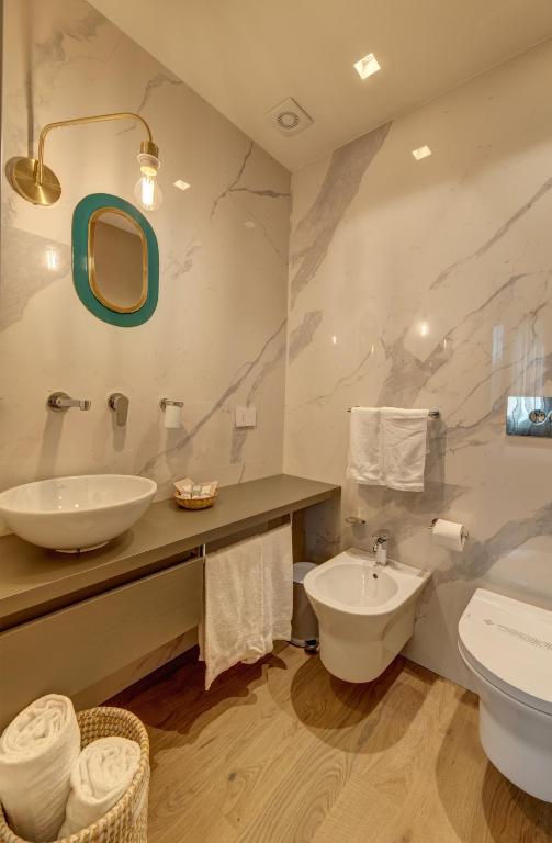 a bathroom with a sink and a toilet at Le Palmette Suites in Cagliari