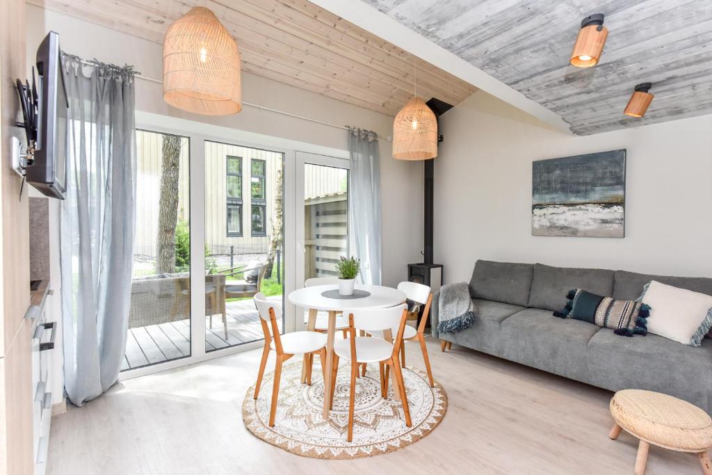 a living room with a couch and a table and chairs at Stunning Seaside Haus in Palanga