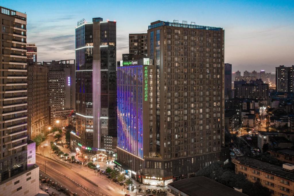 un perfil urbano con edificios altos por la noche en Holiday Inn Express Chengdu West Gate, an IHG Hotel, en Chengdú