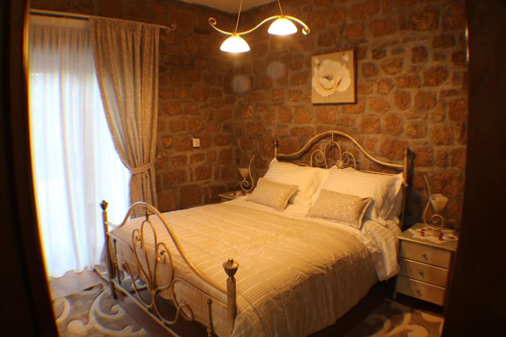 sypialnia z łóżkiem i ceglaną ścianą w obiekcie AELIA HOME w mieście Synikia Mesi Trikalon