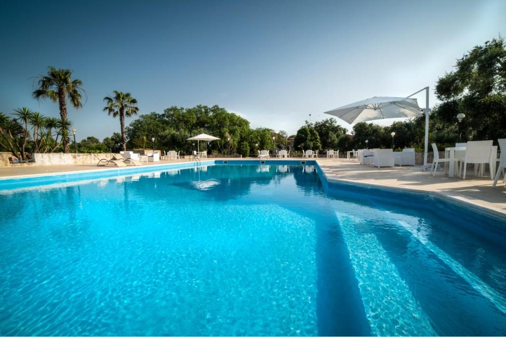 - une piscine d'eau bleue dans un complexe dans l'établissement Relais d 'Itria, à Grottaglie