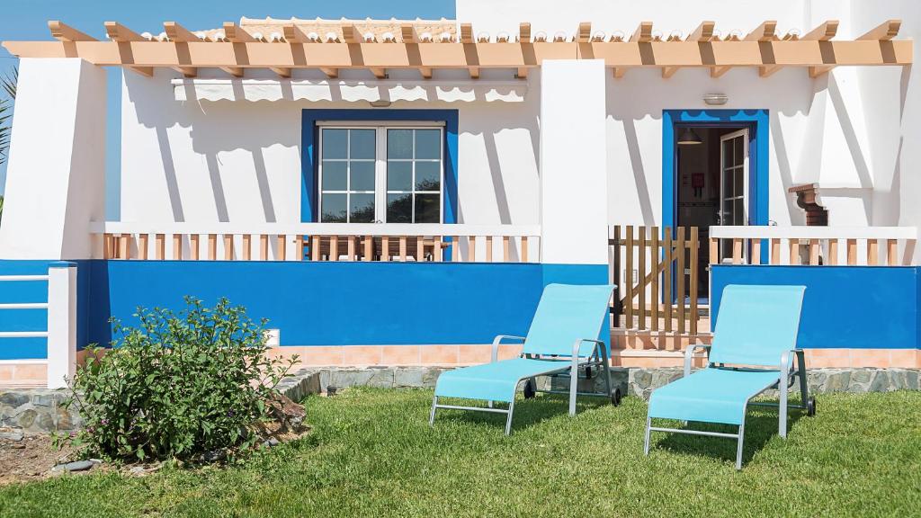 two blue chairs in front of a house at Apartment Praia da Arrifana! in Aljezur