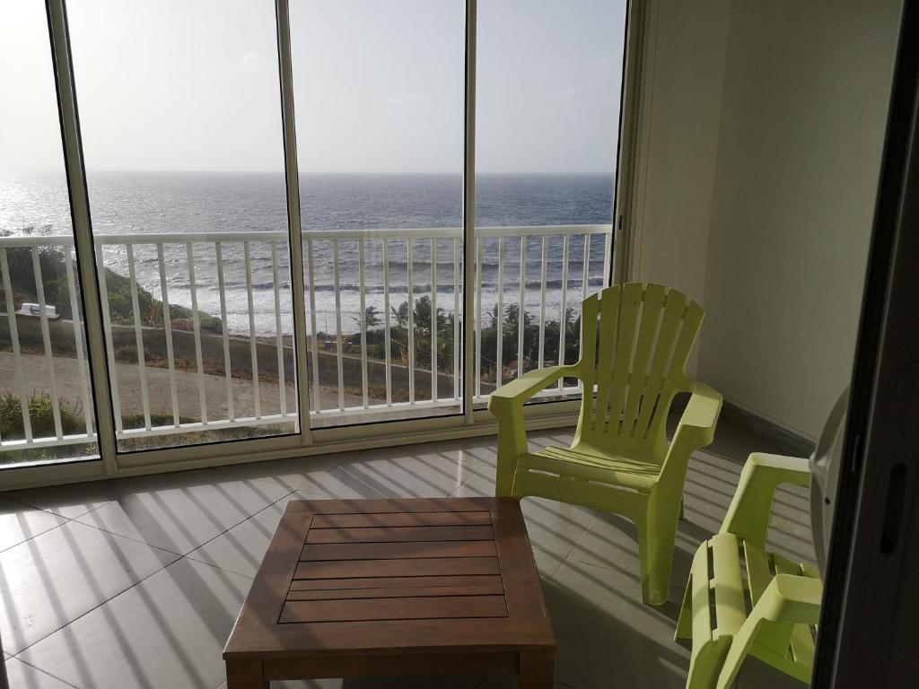 a room with a view of the ocean from a balcony at STUDIO LE PHARE in Terre-de-Haut