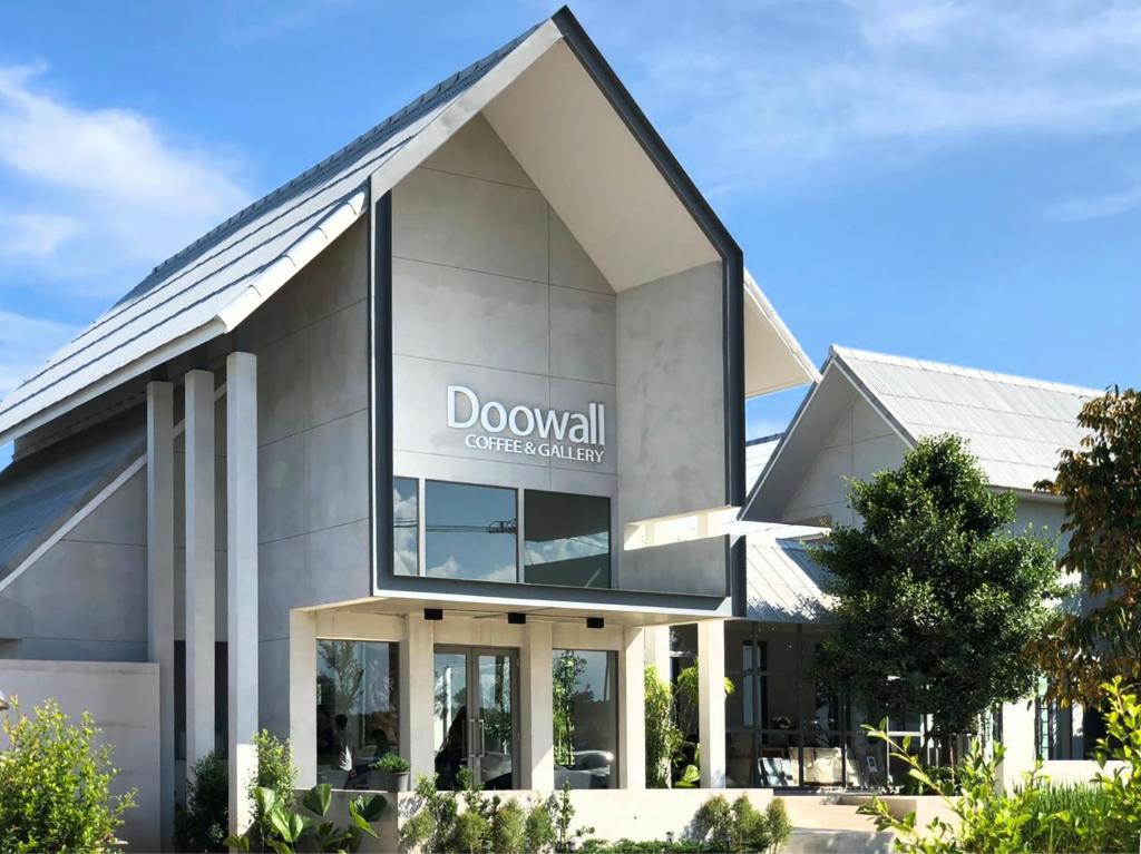 a large white building with a sign on the front of it at Doowall Hotel in Chiang Rai