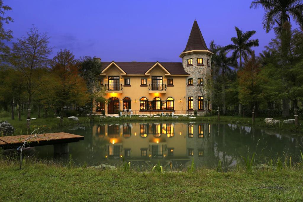 a large house with a pond in front of it at Yun Shan Shuei Castle in Fengping