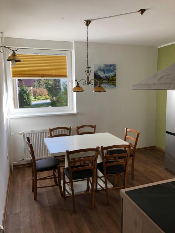 - une cuisine et une salle à manger avec une table et des chaises dans l'établissement APARTMA CARPE DIEM, à Kranjska Gora