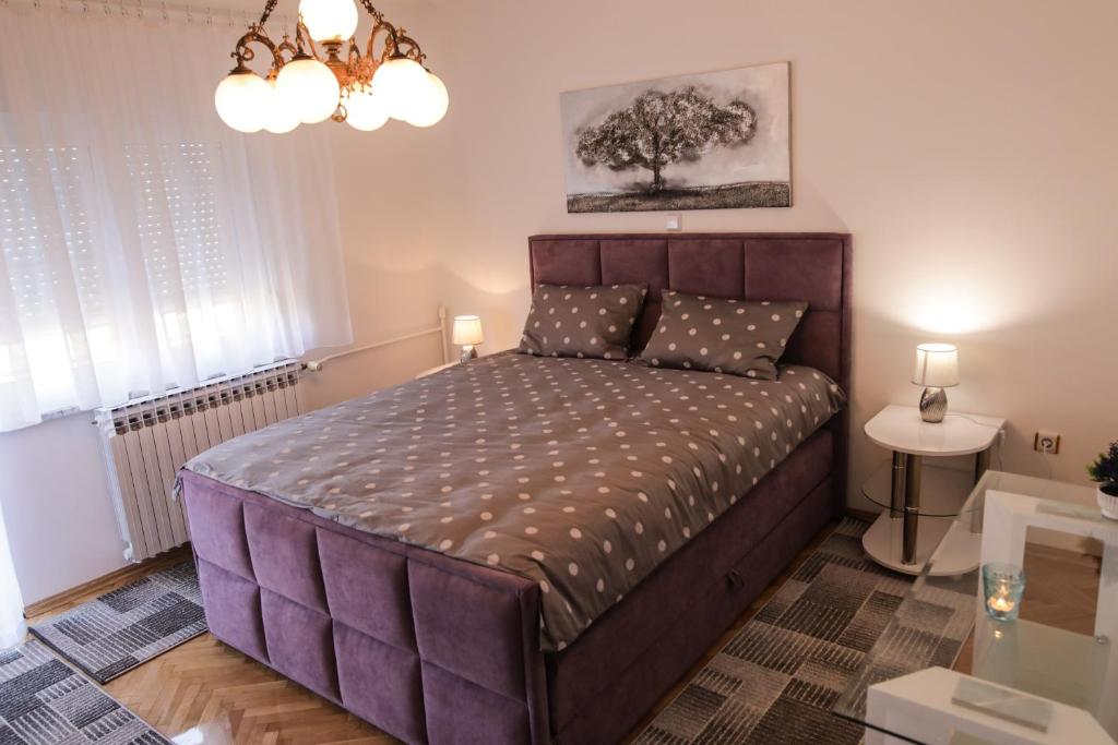 Apartman Kaya في دياكوفو: غرفة نوم مع سرير أرجواني كبير في غرفة