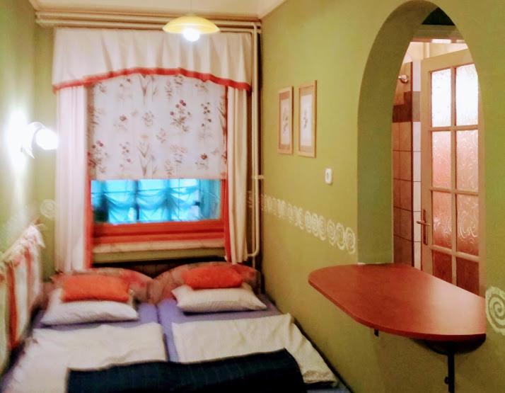 1 Schlafzimmer mit 2 Betten, einem Fenster und einem Tisch in der Unterkunft Nekeczki Vendégház in Nagykáta