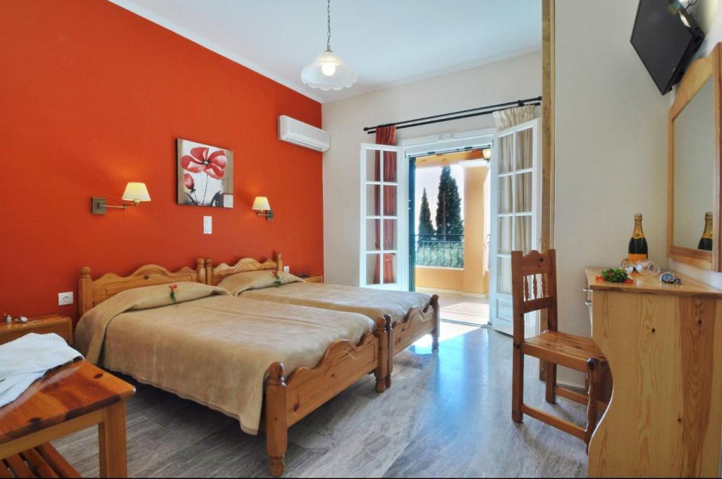 a bedroom with a large bed with orange walls at Rhea Complex in Paleokastritsa