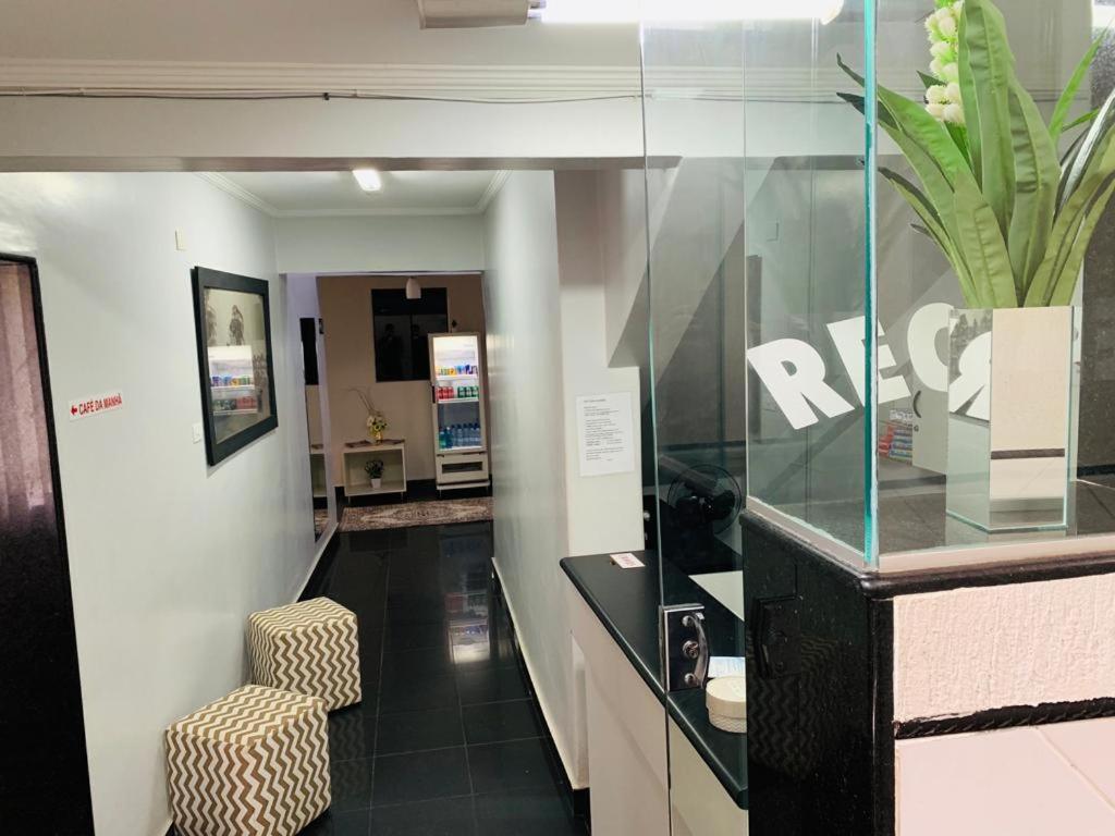 a lobby with a chair and a potted plant at Hotel Central de Anápolis in Anápolis