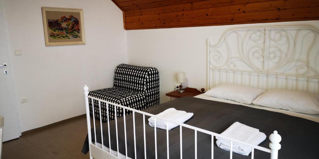 una camera con un letto bianco e una sedia di Vas Lipa 8 - 36 a Podcetrtek