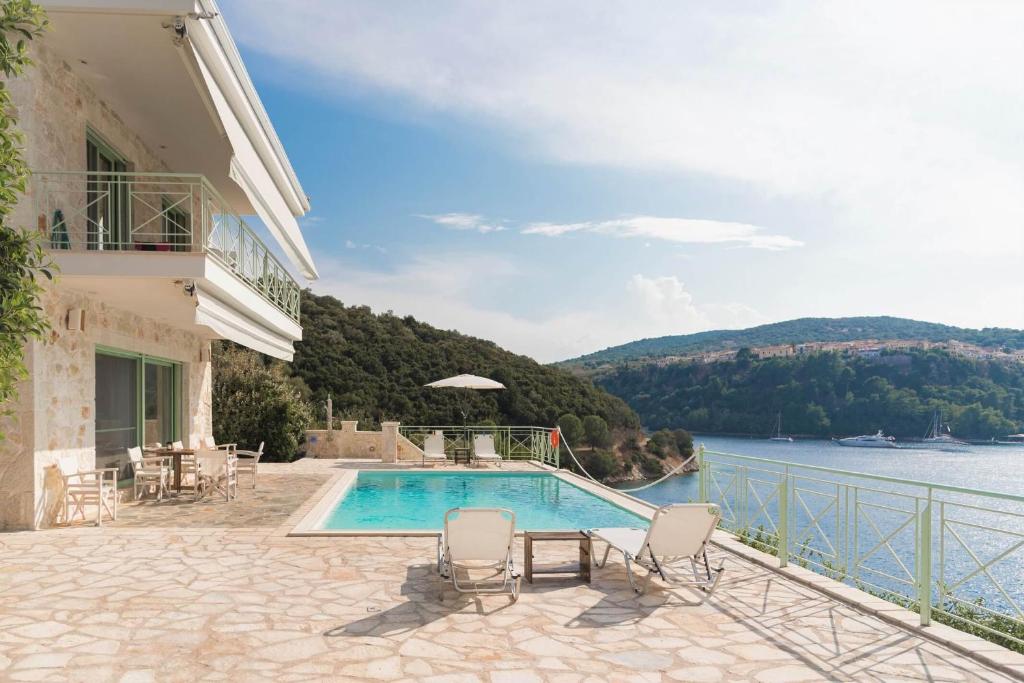 a villa with a swimming pool and a view of the water at Meganisi Blue Villa in Meganisi