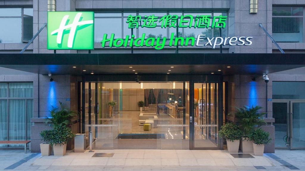 una entrada a un edificio con un cartel en él en Holiday Inn Express Chengdu Airport Zone(Chengdu Shuangliu International Airport Branch), an IHG Hotel en Chengdú