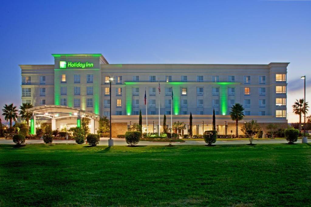 un gran edificio con luces verdes. en Holiday Inn & Suites College Station-Aggieland, an IHG Hotel en College Station