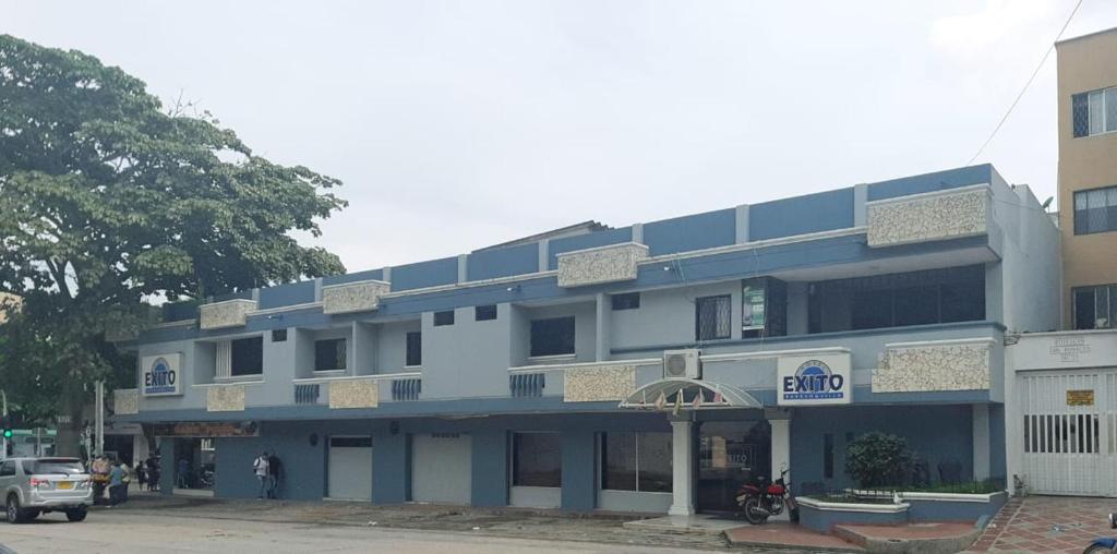 a blue and white building with a car parked in front at Hotel Exito Barranquilla in Barranquilla