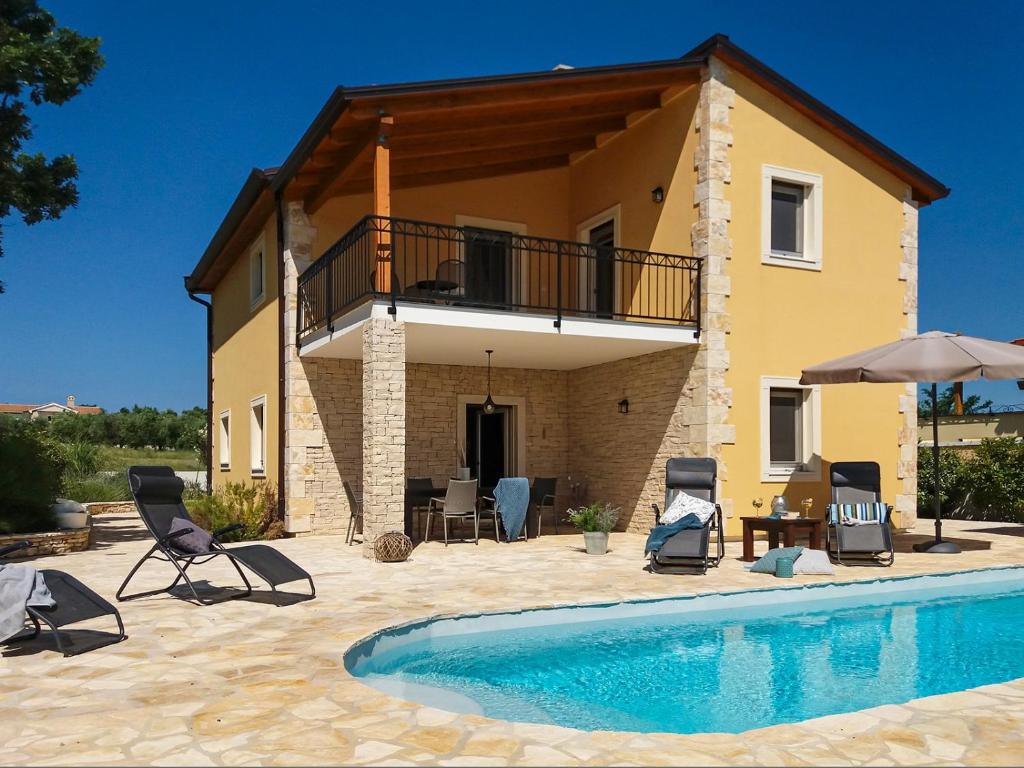 a villa with a swimming pool in front of a house at Villa Jomi in Tar