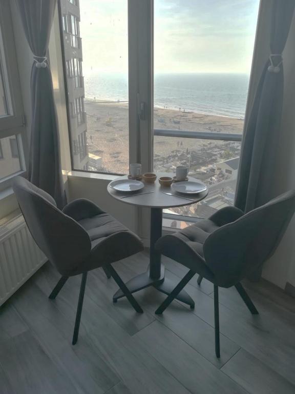 a table and chairs in a room with a view of the beach at WAW vakantie appartement in Middelkerke
