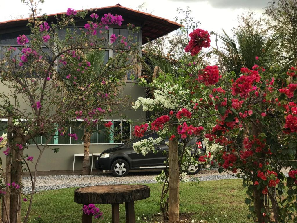 a car parked in front of a house with flowers at Hostel A Cozinha de Cora in Brasilia