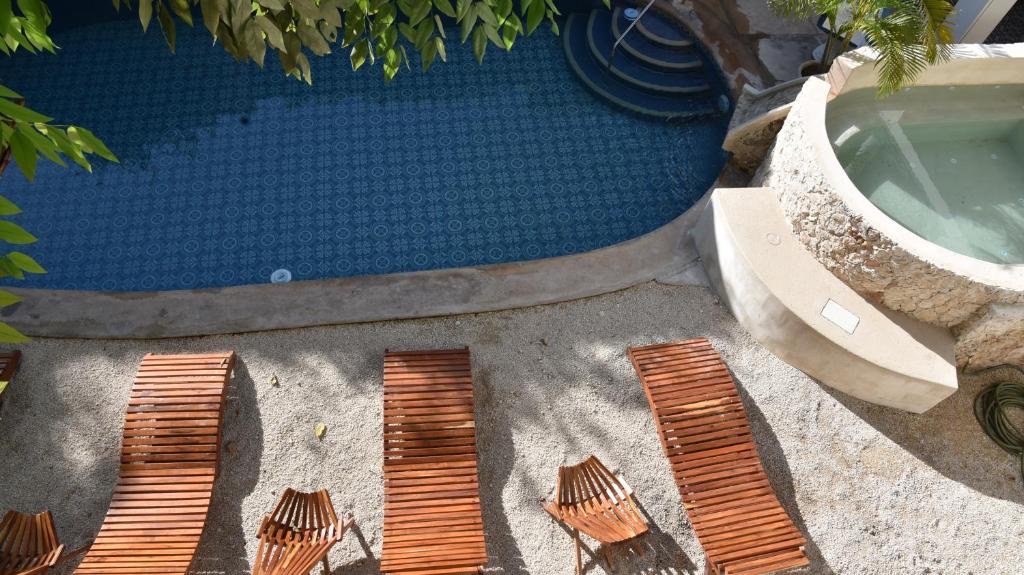 una vista aérea de una piscina con pizarras de madera en el suelo en Hotel Zamna Boutique en Mérida
