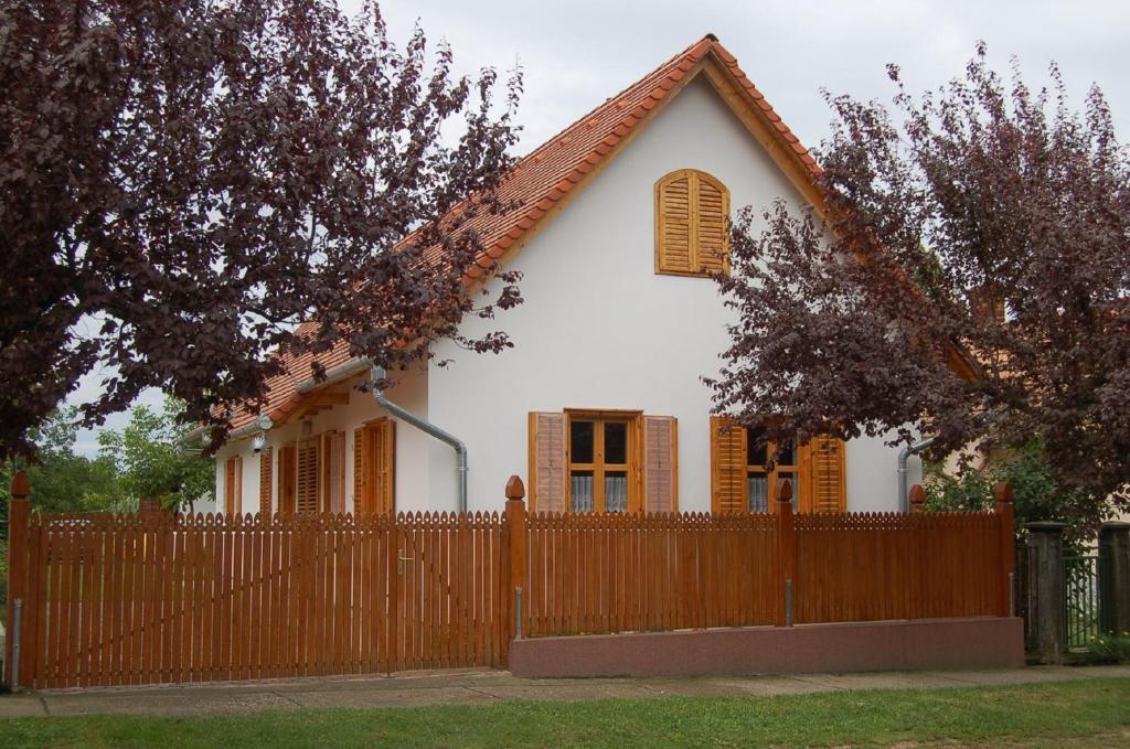 a white house with a wooden fence in front of it at Apartment in Balatonbereny/Balaton 18074 in Balatonberény