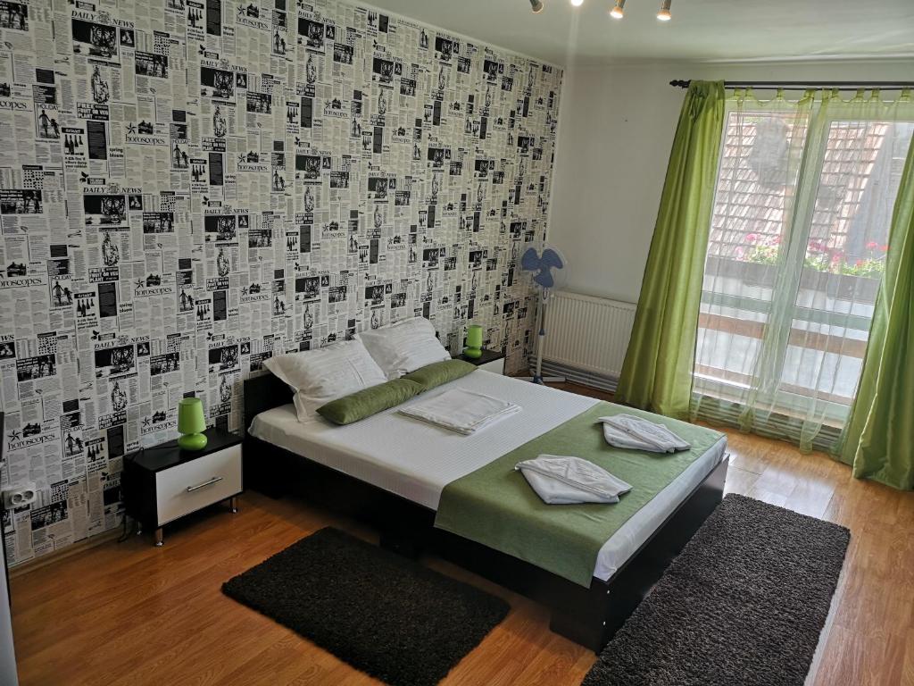 a bedroom with a bed and a wall with posters at Casa Mais in Braşov