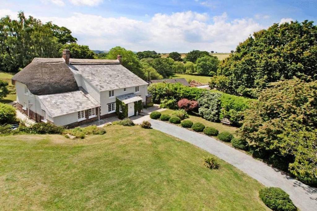 an aerial view of a white house with a thatched roof at Shobrooke Mill Farmhouse in Crediton