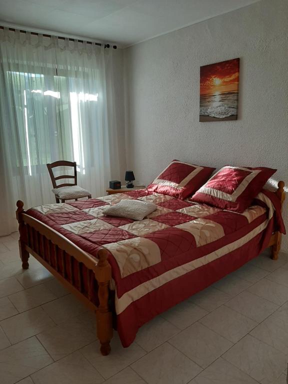 a bedroom with a large bed with a red comforter at Ribellu in Bastia