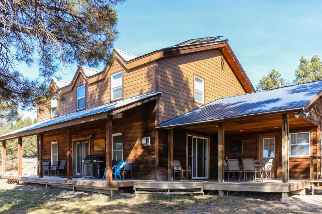 a large wooden house with a wrap around porch at Split Pine Cabin in Pagosa Springs