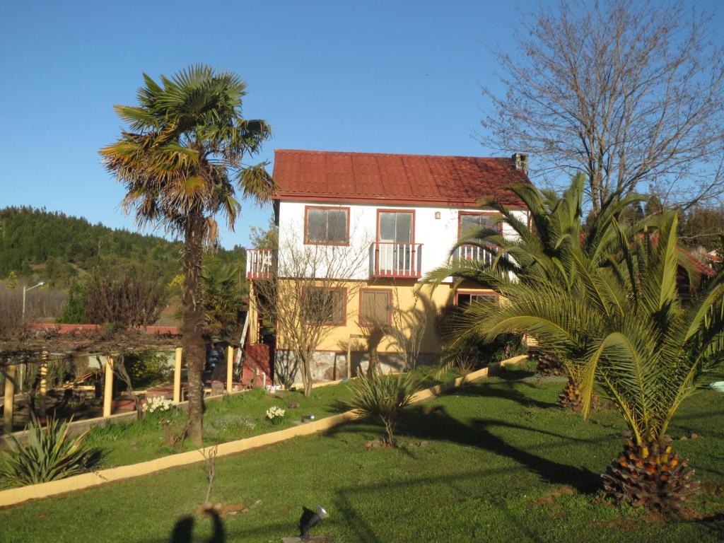 a house with a palm tree in front of it at Cabañas Club Mediterraneo in Quillón