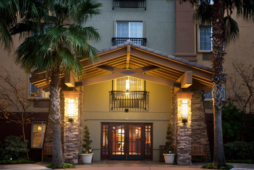 a building with palm trees in front of it at Larkspur Landing Pleasanton-An All-Suite Hotel in Pleasanton