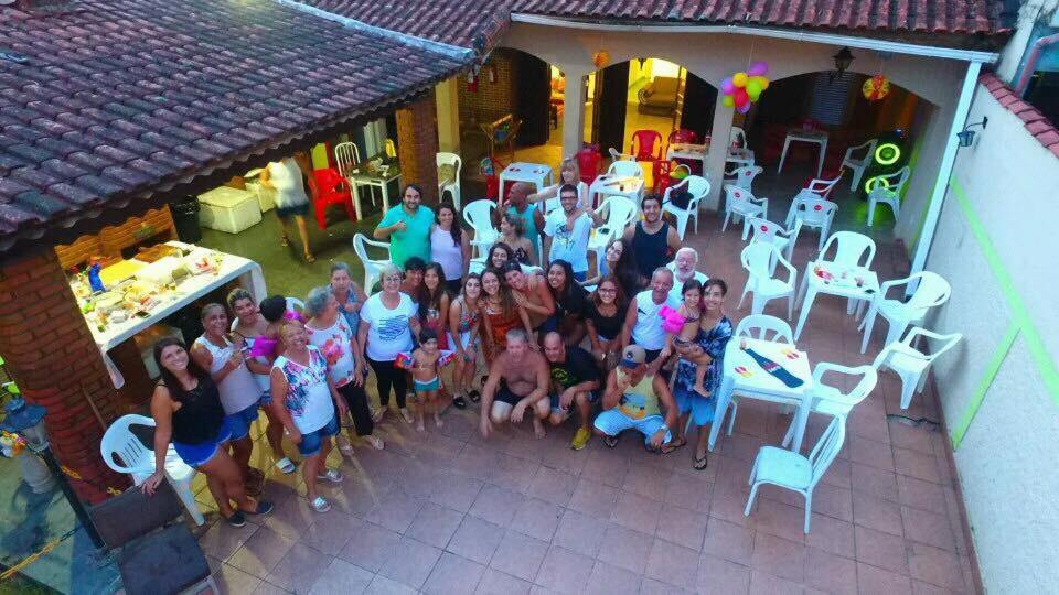 a group of people posing for a picture in front of a house at Casa Guilhermina com Piscina e Churrasqueira in Praia Grande