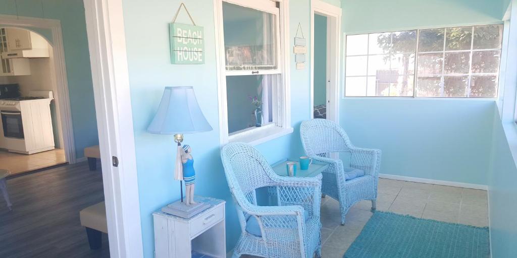 een woonkamer met 2 stoelen en een lamp bij Short walk to beach 3 br 2 bath restored 1935 home in Grover Beach