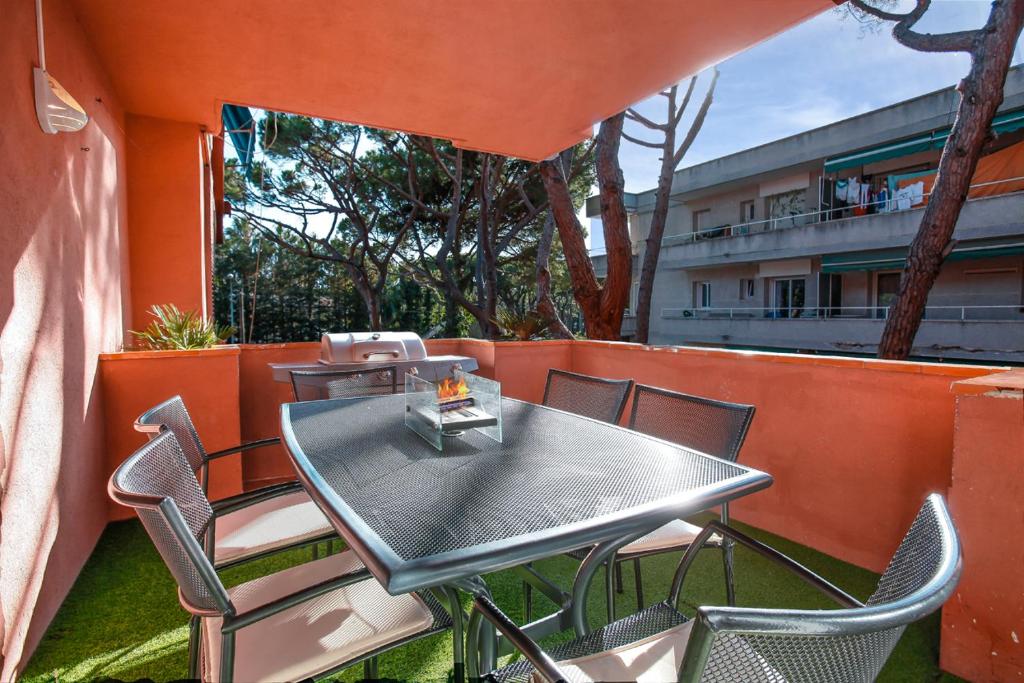 a table and chairs on a balcony with a building at BEACH APARTMENT with BBQ, PS4, BIKES! in Castelldefels