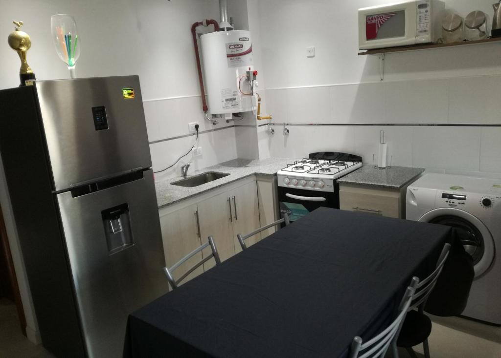 una cucina con tavolo nero e frigorifero di Edificio DOMUS a Necochea