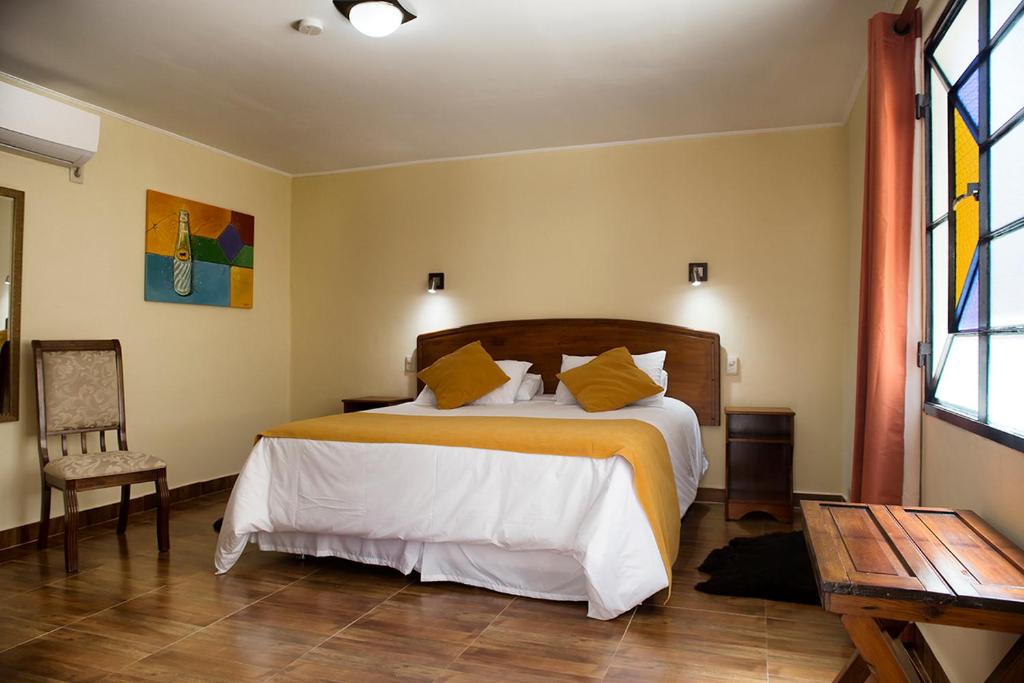 a bedroom with a bed and a table and a window at Hotel FK Paso de los Toros - Hotel Boutique in Paso de los Toros