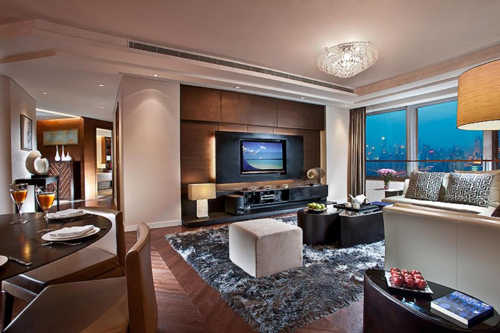 sala de estar con TV, sofá y mesa en Ascott Huai Hai Road Shanghai, Xintiandi, en Shanghái