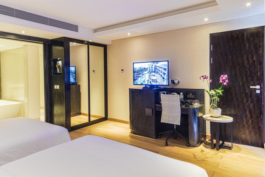 a bedroom with a bed and a tv on a wall at Double - Six, Luxury Hotel - Seminyak in Seminyak