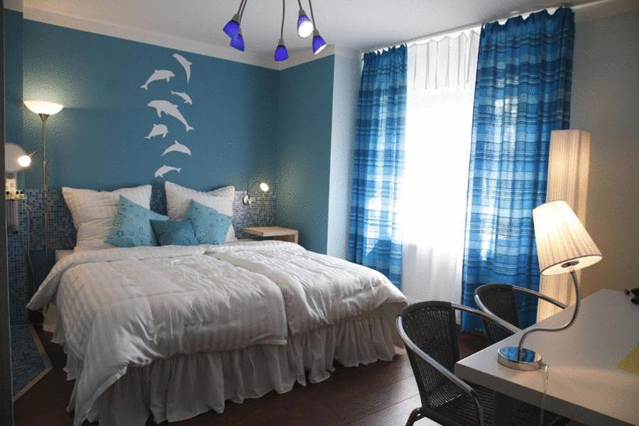 1 dormitorio con 1 cama con delfines en la pared en Art-Hotel Sonnenhof, en Hanau am Main