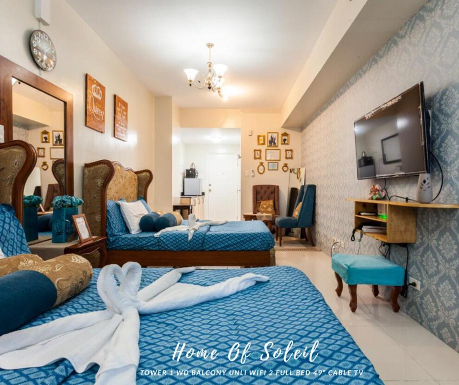 een hotelkamer met 2 bedden en een televisie bij Home Of Soleil in Tagaytay