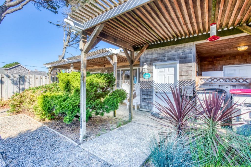 a home with a wooden pergola and a pathway at Sandals Inn | Oceanside Cabana in Cannon Beach