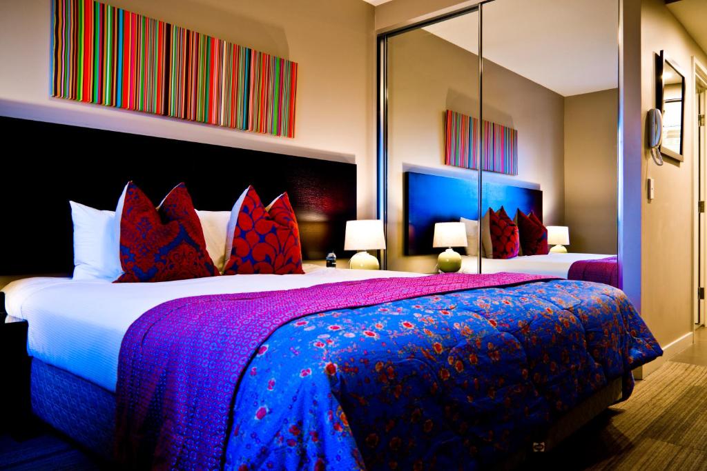 a hotel room with two beds and two lamps at Quest Mascot in Sydney