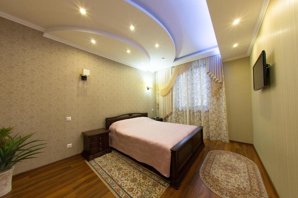 a bedroom with a large bed and a large window at Royal in Zaporozhye