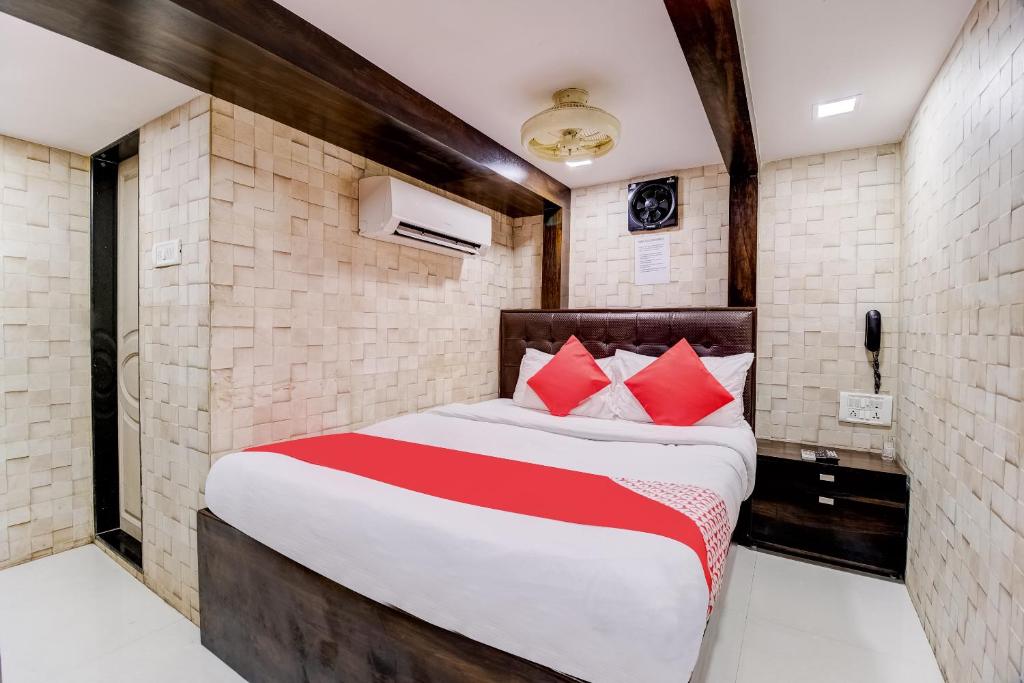 Hotel Qamar في مومباي: غرفة نوم بسرير كبير ومخدات حمراء