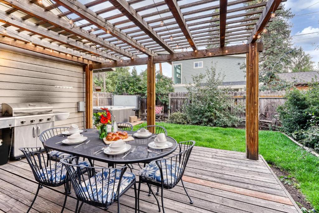 a patio with a table and chairs under a pergola at Perfectly Placed Plum Cottage in Bend