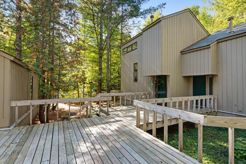 a wooden boardwalk leading to a house in the woods at Harbor Cove #9 in Harbor Springs