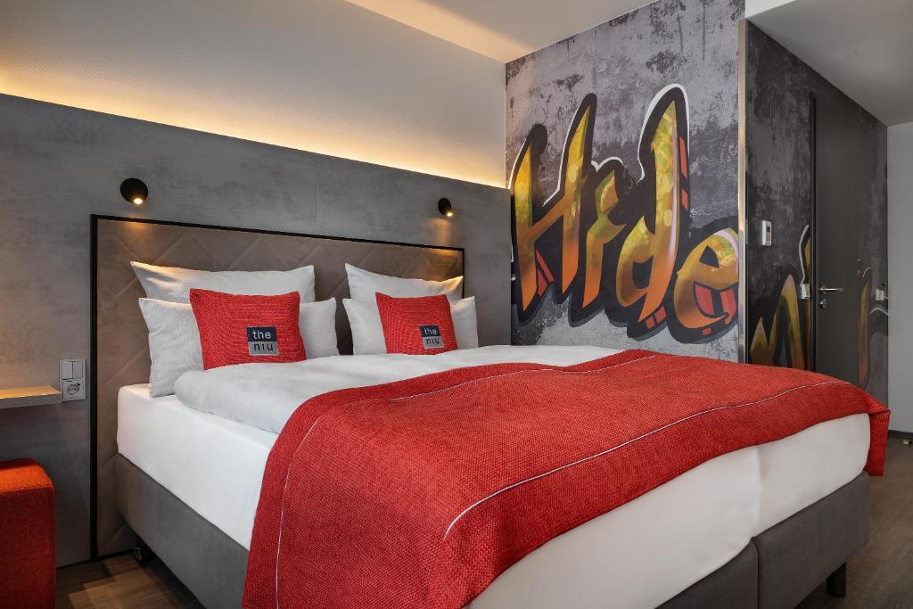 um quarto com uma cama grande e almofadas vermelhas em the niu Hide em Berlim